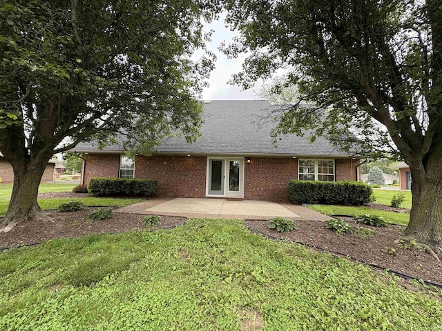 1643 W 1st St, Jasper, IN 47546 - rear view of property featuring a patio, a lawn, brick siding, and a shingled roof