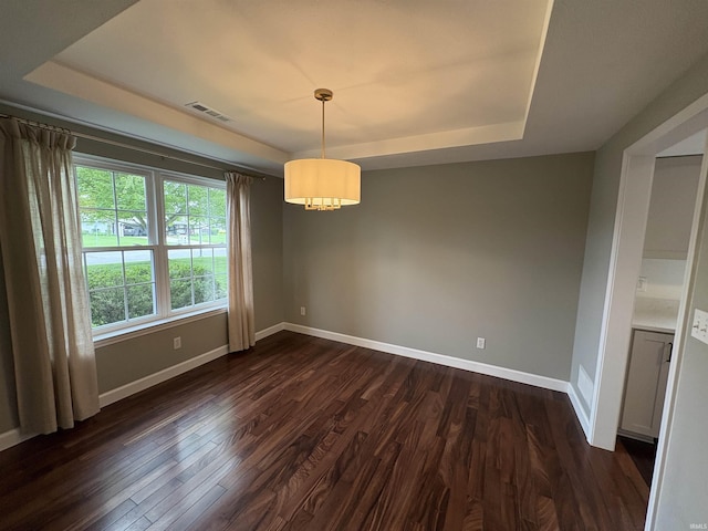 1643 W 1st St, Jasper, IN 47546 - unfurnished dining area with a raised ceiling, baseboards, dark wood-style flooring, and a chandelier