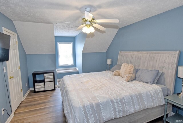 8122 Covington Ct, Newburgh, IN 47630 - bedroom with wood finished floors, vaulted ceiling, a textured ceiling, ceiling fan, and baseboards