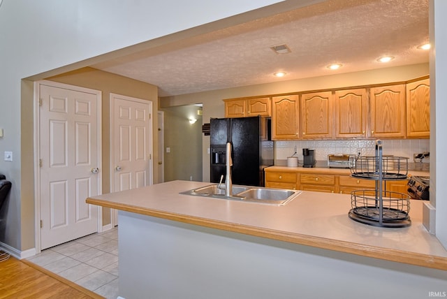 8122 Covington Ct, Newburgh, IN 47630 - kitchen with black refrigerator with ice dispenser, a sink, decorative backsplash, a textured ceiling, and a peninsula