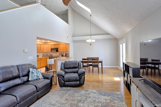 8122 Covington Ct, Newburgh, IN 47630 - living area featuring lofted ceiling, a chandelier, a textured ceiling, light wood-style floors, and a skylight