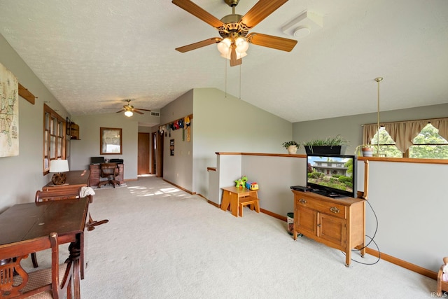 living area featuring a ceiling fan, lofted ceiling, baseboards, and carpet floors