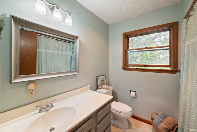 bathroom featuring vanity, toilet, a textured ceiling, and baseboards