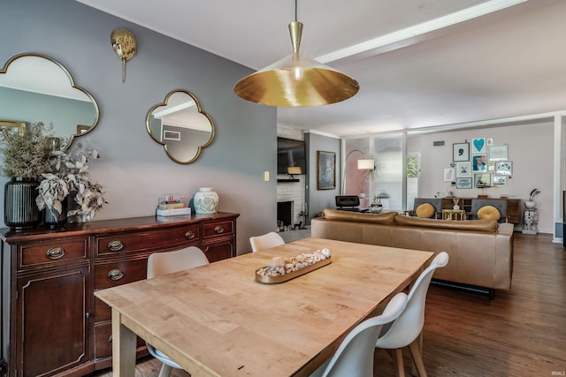 dining room featuring dark wood finished floors and a fireplace
