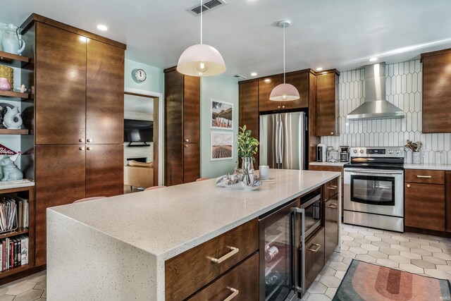 kitchen with stainless steel appliances, wall chimney exhaust hood, wine cooler, pendant lighting, and light tile patterned flooring
