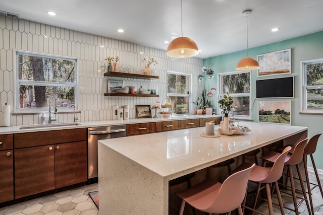 bar area with a sink, dishwasher, recessed lighting, light tile patterned flooring, and hanging light fixtures