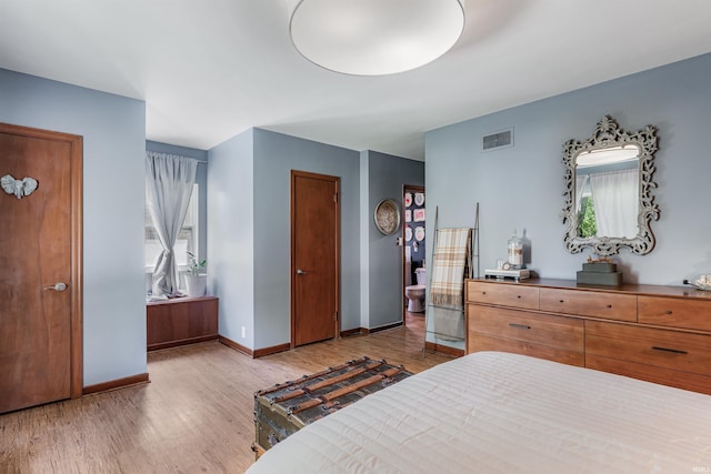 bedroom featuring light wood finished floors, multiple windows, and baseboards