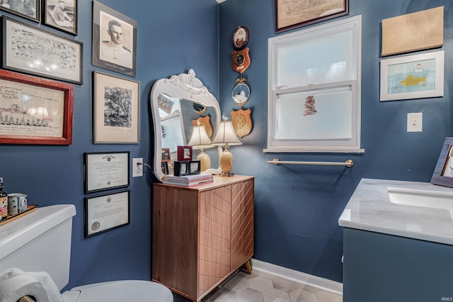 bathroom featuring baseboards, toilet, vanity, and tile patterned floors