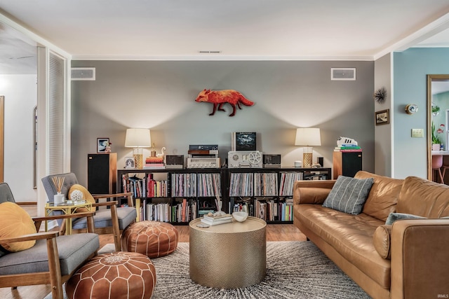 living area with wood finished floors and crown molding
