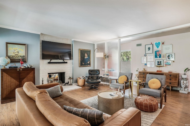 living room featuring a multi sided fireplace, wood finished floors, and crown molding
