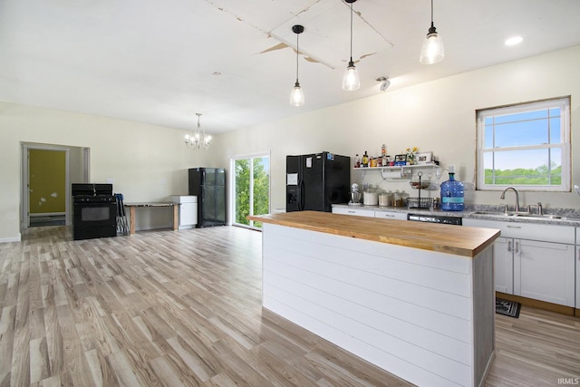 5025 N Elder Rd, Larwill, IN 46764 - kitchen with butcher block counters, black appliances, a chandelier, and light wood-style floors