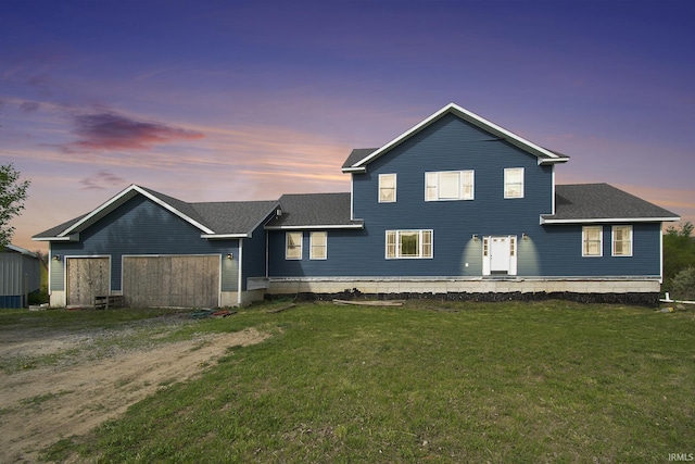 5025 N Elder Rd, Larwill, IN 46764 - rear view of house with a lawn, dirt driveway, a shingled roof, and an attached garage