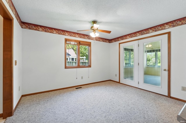 unfurnished room featuring carpet floors, a textured ceiling, ceiling fan, and baseboards