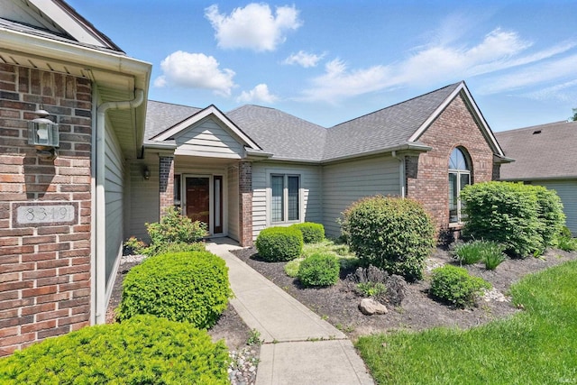 view of front of house featuring brick siding and a shingled roof