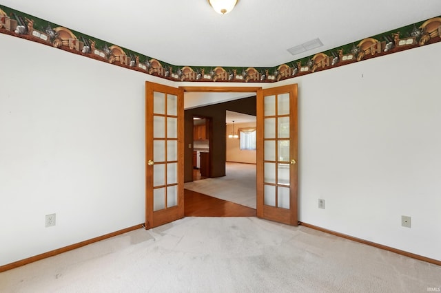 empty room with french doors, carpet floors, and baseboards