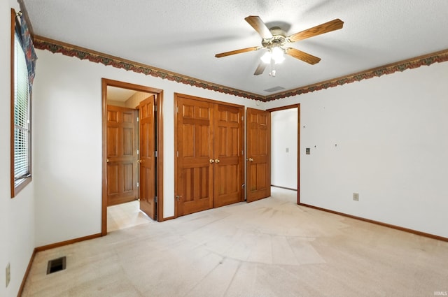 unfurnished bedroom with light colored carpet, baseboards, ceiling fan, and a closet