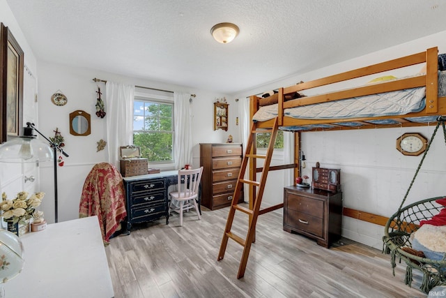 bedroom with light wood finished floors and a textured ceiling