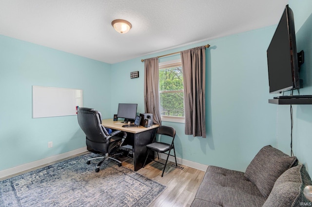 office space with light wood-style flooring and baseboards