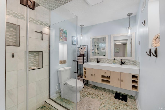 bathroom featuring toilet, a shower stall, double vanity, and tasteful backsplash