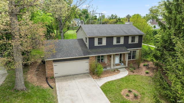 traditional-style home with roof with shingles, brick siding, a garage, concrete driveway, and covered porch