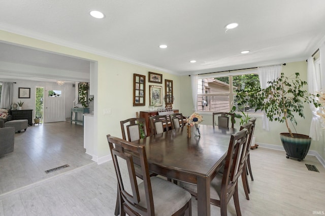 dining space featuring light wood-type flooring, recessed lighting, ornamental molding, and baseboards