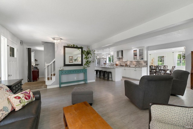 living room featuring stairway, light wood-type flooring, and baseboards
