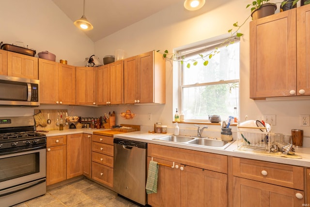 708 W 7th St, Bloomington, IN 47404 - kitchen featuring appliances with stainless steel finishes, a sink, light countertops, vaulted ceiling, and hanging light fixtures