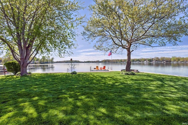 view of green lawn with a water view
