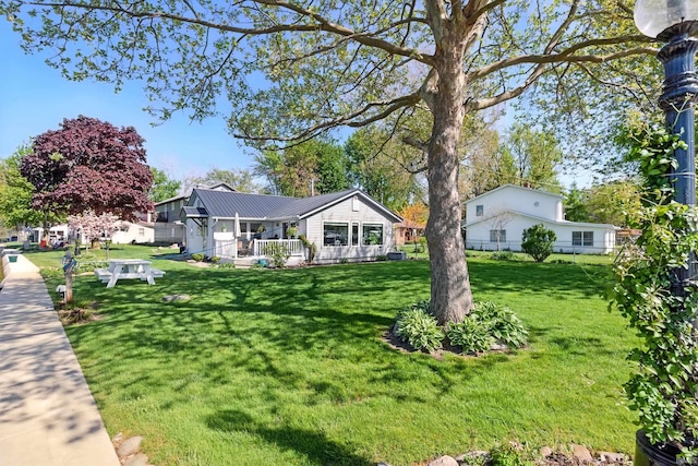 view of front of house featuring a front lawn and metal roof