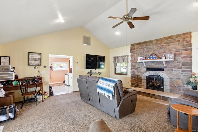 living room featuring ceiling fan, carpet, a stone fireplace, and high vaulted ceiling