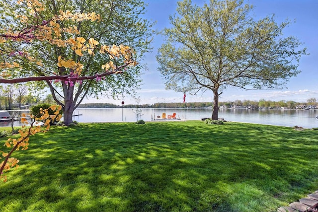 view of green lawn with a water view