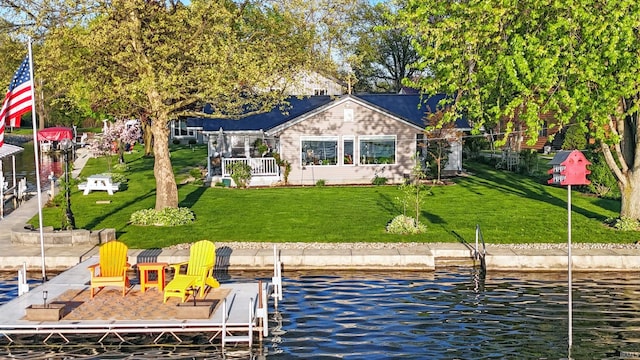 back of house featuring a lawn and a water view