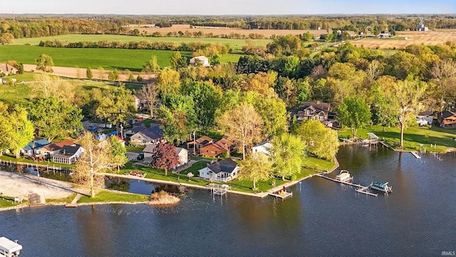 aerial perspective of suburban area featuring a nearby body of water and a tree filled landscape