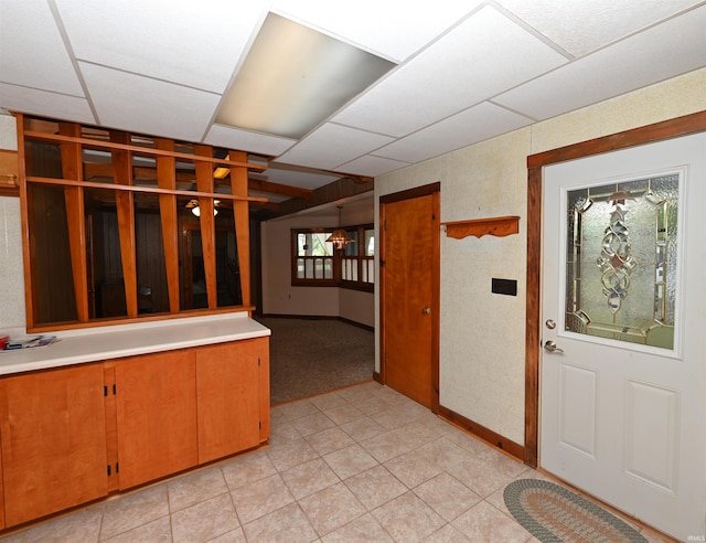 foyer entrance with a paneled ceiling and baseboards