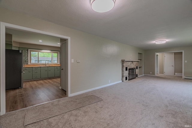 546 W Harrison, Wabash, IN 46992 - unfurnished living room with a sink, carpet flooring, a glass covered fireplace, and baseboards