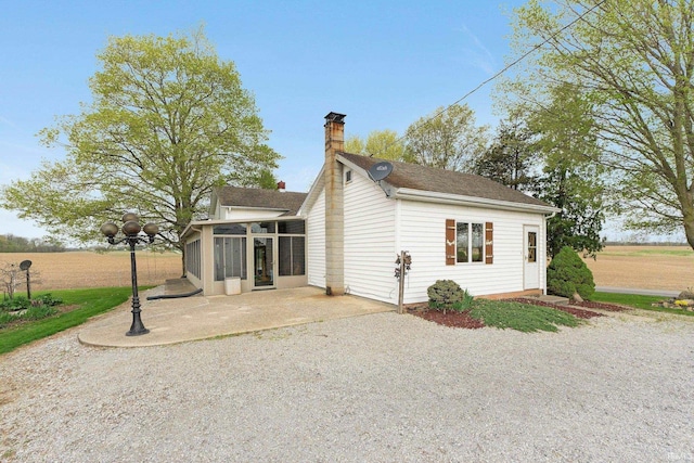 3648 E 300 S, Albion, IN 46701 - rear view of property featuring a sunroom, a chimney, a patio, and roof with shingles