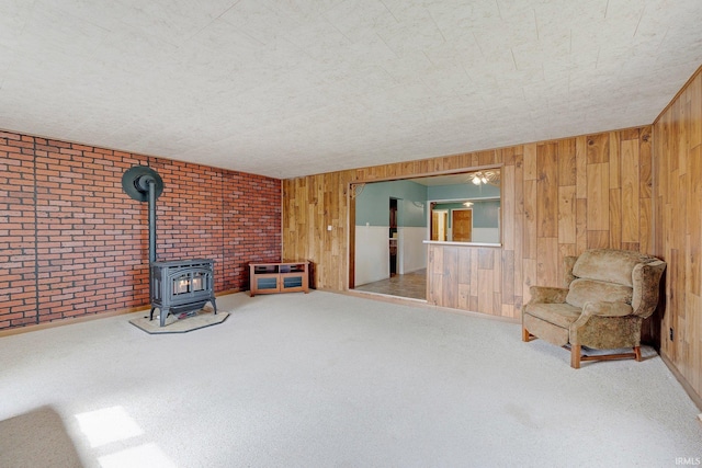 3648 E 300 S, Albion, IN 46701 - unfurnished room with a wood stove, wooden walls, and carpet flooring
