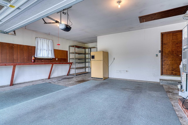 844 Old Plank Rd, Chandler, IN 47610 - garage with freestanding refrigerator, a garage door opener, and wood walls