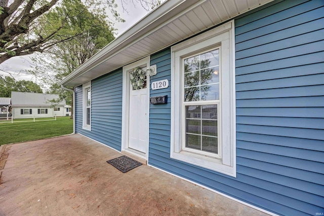 doorway to property featuring a yard and a patio area
