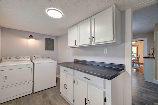 laundry area with washing machine and dryer, wood finished floors, a textured ceiling, cabinet space, and electric panel
