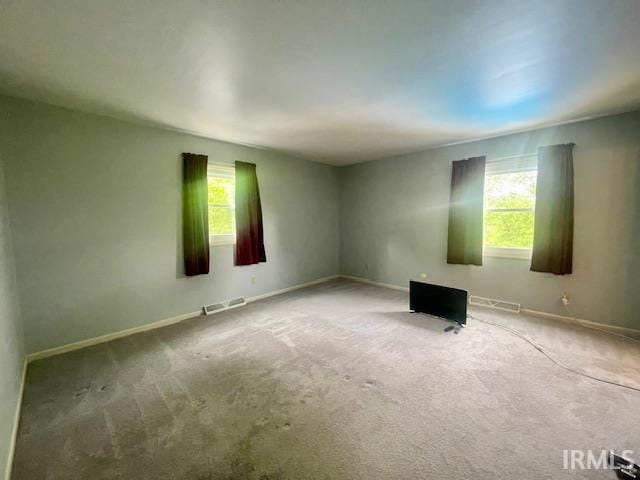 carpeted empty room with baseboards