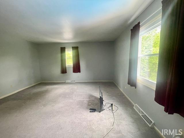 carpeted spare room with baseboards