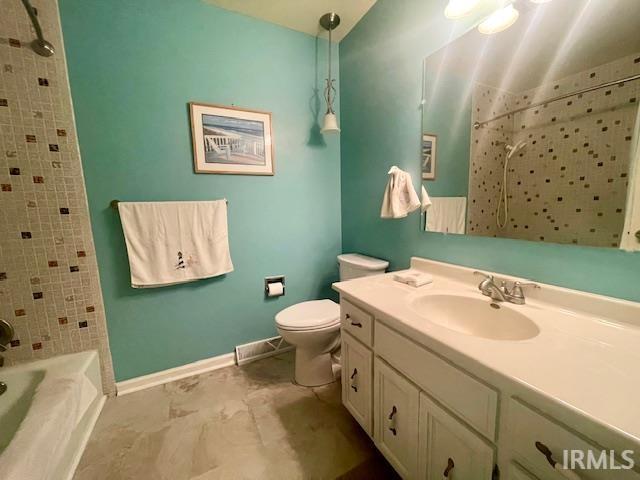 full bath with toilet, vanity, baseboards, and shower / bath combination