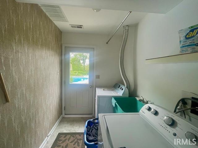 laundry room featuring washing machine and dryer and baseboards