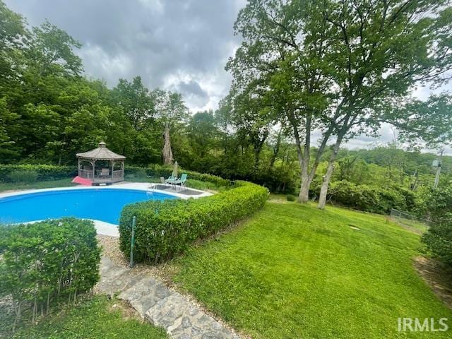 outdoor pool with a gazebo, a patio, and a yard