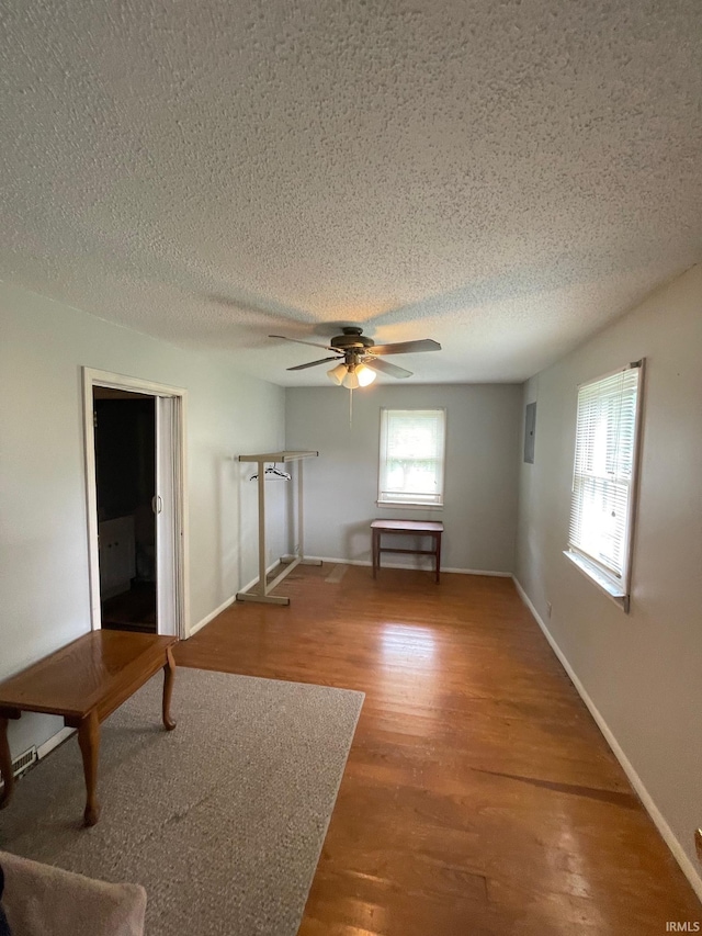 109 S 3rd St, Edwardsport, IN 47528 - unfurnished living room with a textured ceiling, wood finished floors, ceiling fan, and baseboards