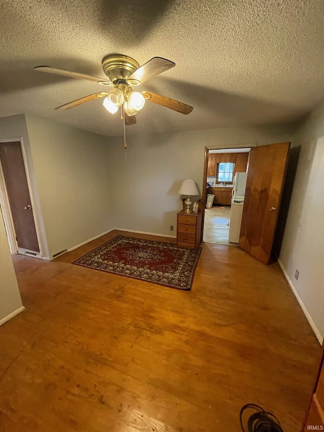 109 S 3rd St, Edwardsport, IN 47528 - empty room with a textured ceiling, a ceiling fan, baseboards, and wood finished floors