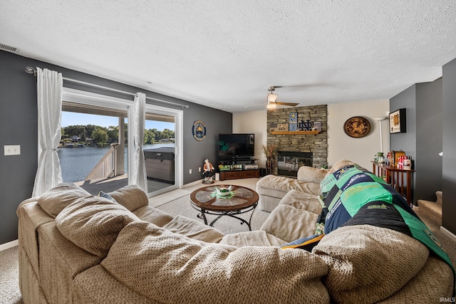 10140 Jefferson Rd, Osceola, IN 46561 - carpeted living room featuring a ceiling fan, a textured ceiling, baseboards, and a stone fireplace