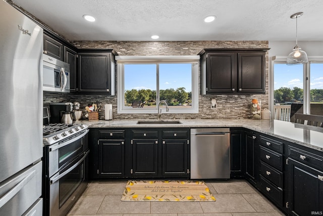 10140 Jefferson Rd, Osceola, IN 46561 - kitchen featuring appliances with stainless steel finishes, a sink, dark cabinets, backsplash, and light tile patterned floors