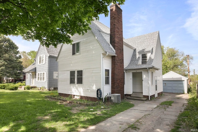 3205 S Michigan St, South Bend, IN 46614 - view of side of home with a garage, an outbuilding, roof with shingles, and a lawn